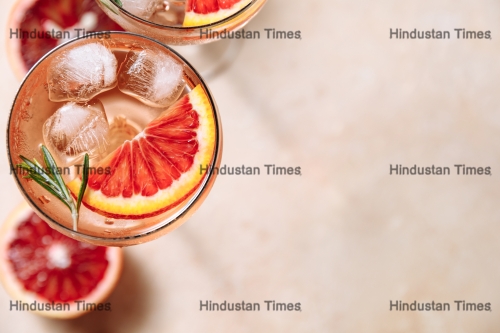 Summer,Cocktail,With,Blood,Orange,,Grapefruit,And,Rosemary,On,Beige