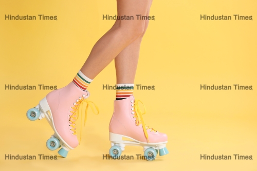 Young,Woman,With,Retro,Roller,Skates,On,Color,Background,,Closeup