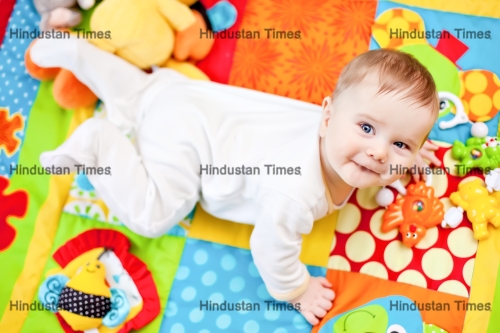 Closeup,Of,Happy,Six,Months,Baby,Boy,Crawling,On,Colorful