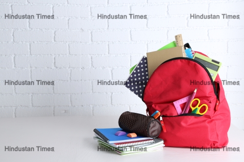Backpack,With,School,Supplies,On,Wooden,Table,,On,Wall,Background