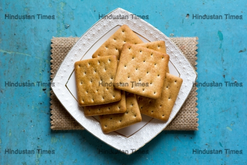 Cracker,Biscuits,In,A,White,Ceramic,Square,Saucer,On,Linen