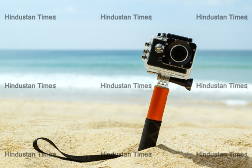 Action,Camera,In,Waterproof,Case,With,Monopod,On,The,Beach