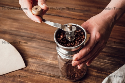 Grinding,Coffee,Beans,In,A,Manual,Coffee,Grinder,On,A