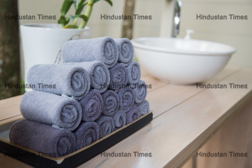 Rolled,Towels,In,Wooden,Tray,At,Clean,Bathroom
