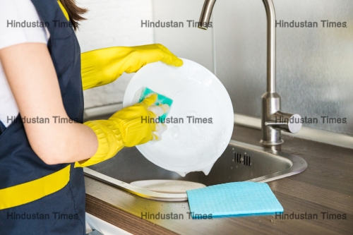 A,Young,Woman,In,Yellow,Gloves,Washes,Dishes,With,A