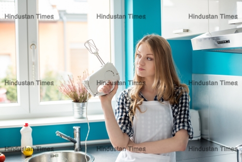 Beautiful,Young,Blond,Woman,Standing,In,Front,Of,The,Kitchen