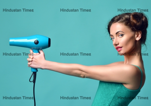 Happy,Young,Curly,Brunette,Woman,With,Hair,Dryer,On,Blue
