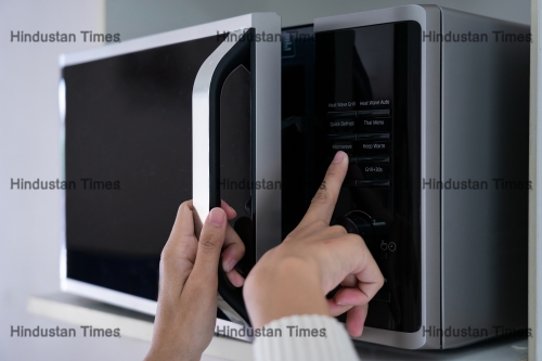 Woman's,Hands,Closing,The,Microwave,Oven,Door,And,Preparing,Food