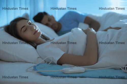 Couple,Sleeping,On,Electric,Heating,Pad,In,Bed,At,Night
