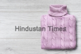 Pink,Sweater,Folded,On,White,Wooden,Background