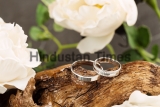 Two,Platinum,Wedding,Rings,On,Wood,Background,With,Flowers.,Bride