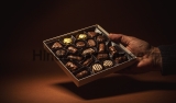 Male,Hand,Is,Holding,An,Open,Box,Of,Chocolates.