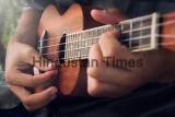 A,Man,Playing,Ukulele,In,Close,Up,View.