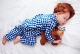 Adorable,Redhead,Toddler,Baby,Sleeping,With,Plush,Toy,In,Flannel