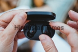 Close-up,Of,A,Woman,Taking,Out,A,Wireless,Earbud,From