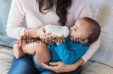 Little,Infant,Baby,Lying,On,Mothers,Hand,Drinking,Milk,From