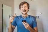 Young,Man,Brush,Teeth,Using,Activated,Charcoal,Powder,For,Brushing