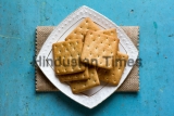 Cracker,Biscuits,In,A,White,Ceramic,Square,Saucer,On,Linen