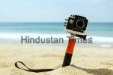 Action,Camera,In,Waterproof,Case,With,Monopod,On,The,Beach