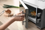 Young,Woman,Using,Microwave,Oven,On,Table,In,Kitchen