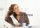 Happy,Young,Woman,Blow,Drying,Hair,In,Bathroom