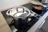 Cooking,Pot,With,Chrome-plated,Lid,On,A,Cooktop,With,Extractor