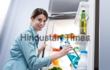 Young,Woman,Taking,A,Water,Bottle,From,Refrigerator,And,Smiling