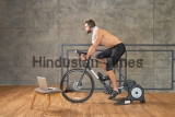 Athletic,Young,Man,Having,Stationary,Bike,Workout,At,Home