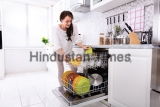 Smiling,Young,Woman,Arranging,Plates,In,Dishwasher,At,Home