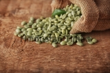 Coffee,Grains,With,Green,Leaf,In,Sackcloth,On,Wooden,Table